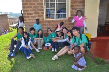 Ten students present a T-shirt written with words of blessings to Henry, the children they sponsor.