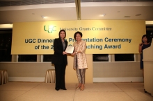 Prof. Poon Wai-yin receives the commemorative plaque from Mrs. Laura Cha, the UGC Chairman.