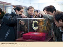 Chinese scholars discussing the craftsmanship of the Dongguaibanggou jade dragon.