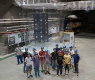 The students and researchers from CUHK and HKU pose for a photo in front of a full size anti-neutrino detector model at the underground Daya Bay Far Experimental Hall.