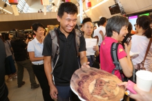 Colleagues pass round a ‘CUHK Mooncake’ signifying the sharing of a caring heart.