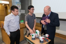 Professor Darwin Lau, CUHK Department of Mechanical and Automation Engineering (left) intorduces the CUHK developed robot arm used for teaching (CUTeR arm) to Dr. Chris Terman, MIT (right).