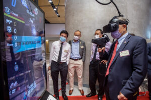 Professor Rocky Tuan tries out the newest digital entertainment in the interactive display area of entrepreneurial projects.