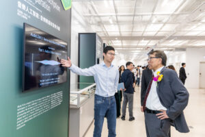 Professor Kong Qiuqiang (left) introduces the use of AI for music transcription and music separation to CUHK Vice-Chancellor and President Professor Rocky S. Tuan (right).